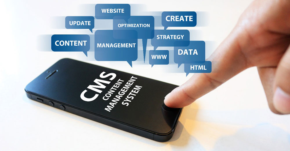 這張圖片展示了一隻手正在觸碰手機螢幕，手機上顯示「CMS (Content Management System)」字樣，周圍圍繞著與網站管理相關的詞語，如「CONTENT」、「WEBSITE」、「CREATE」、「UPDATE」等，象徵內容管理系統的功能和重要性。圖像強調了使用CMS進行網站管理的便捷性與多樣性。